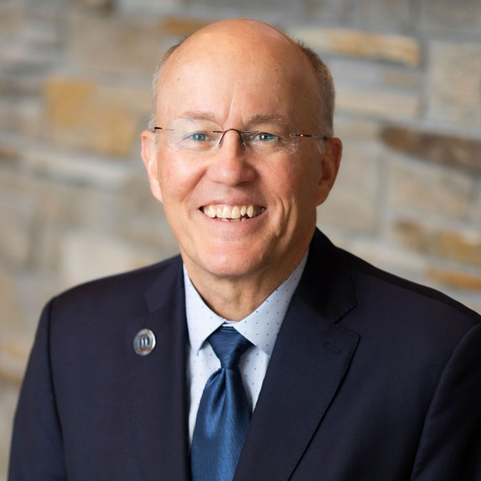 headshot of brad johnson wearing blue suit and tie
