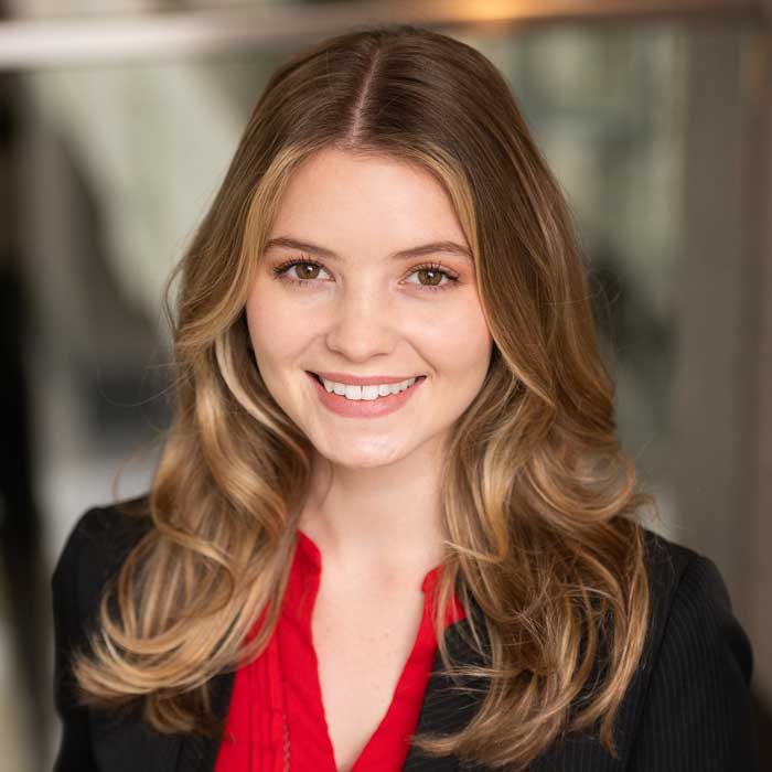 headshot of colette gannon wearing red shirt and black blazer