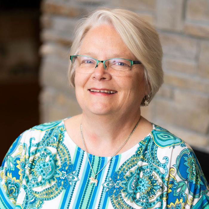 headshot of joann strommen wearing paisley patterned shirt