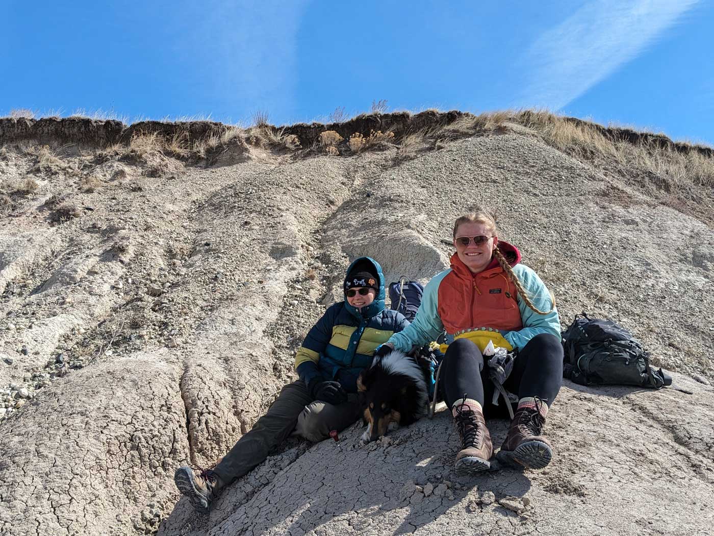 KK-Paleontology-Services-web two women and a dog wearing winter and hiking apparel in the desert mountains