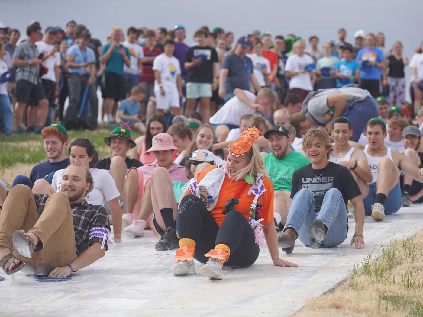 students sliding down a hill on the bottoms with paint