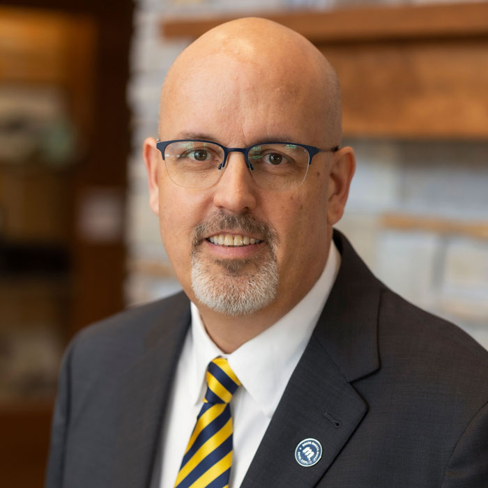headshot of marc vaillancourt wearing grey suit and tie