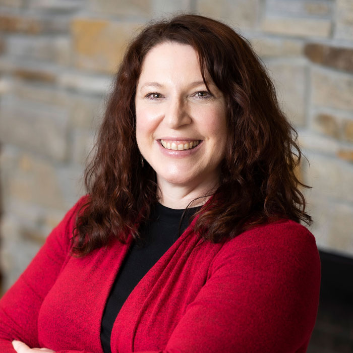 headshot of nicole haltiner wearing red cardigan and black shirt