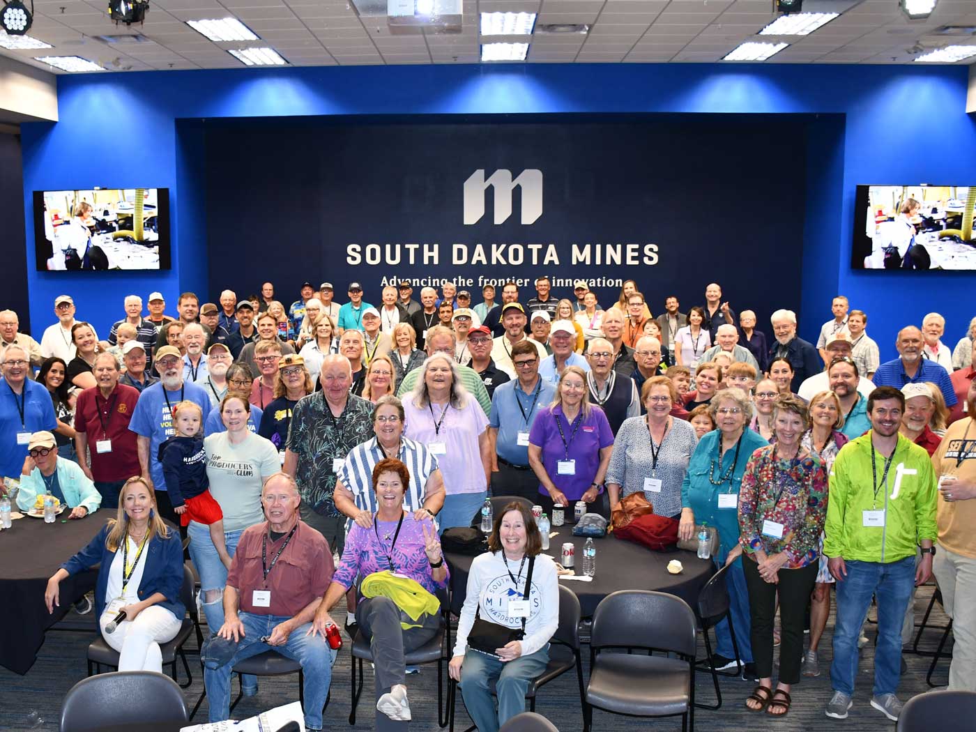 group of people standing in front of blue wall