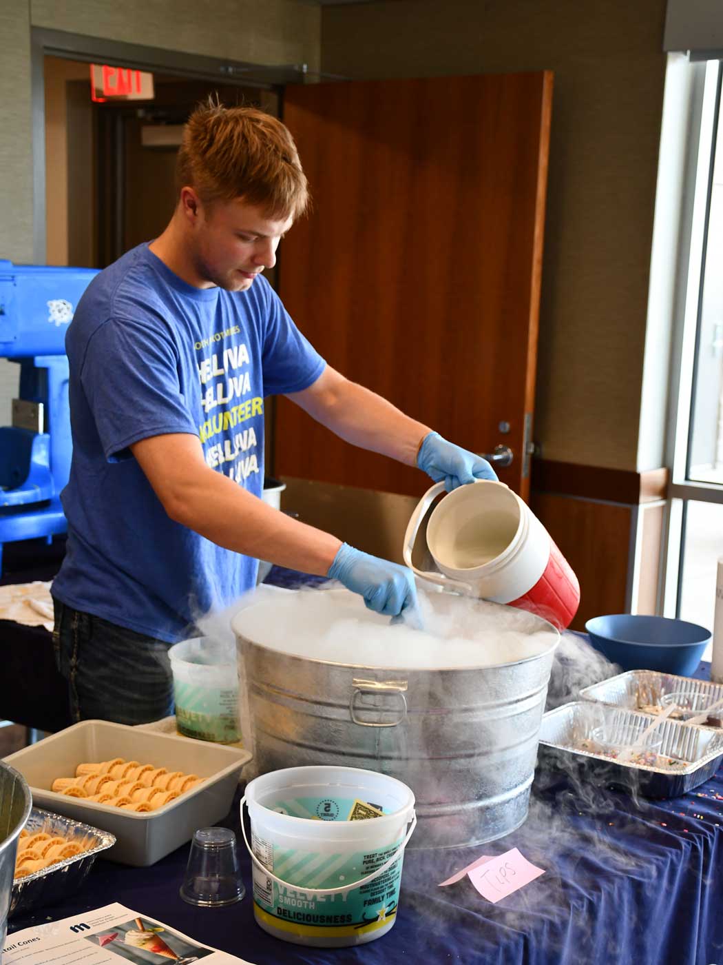student wearing blue shirt making liquid nitrogen ice cream