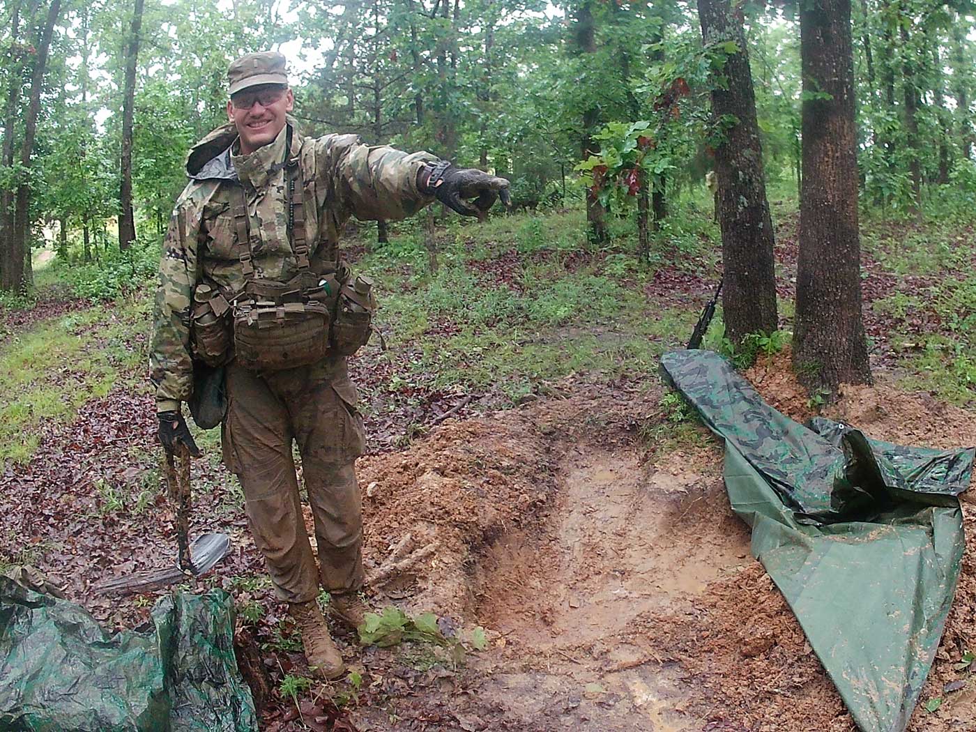 man in military uniform standing in forest pointing into distance