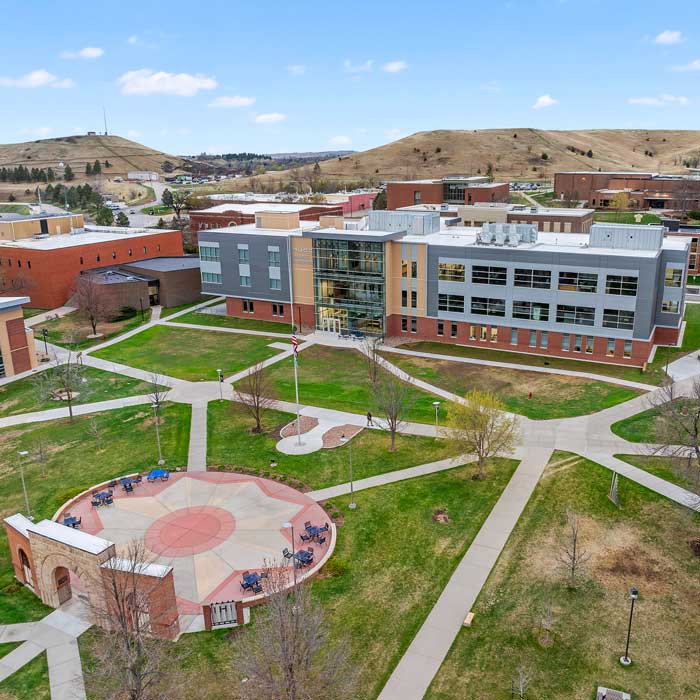 aerial shot of a campus quad with brick arch and large buildling